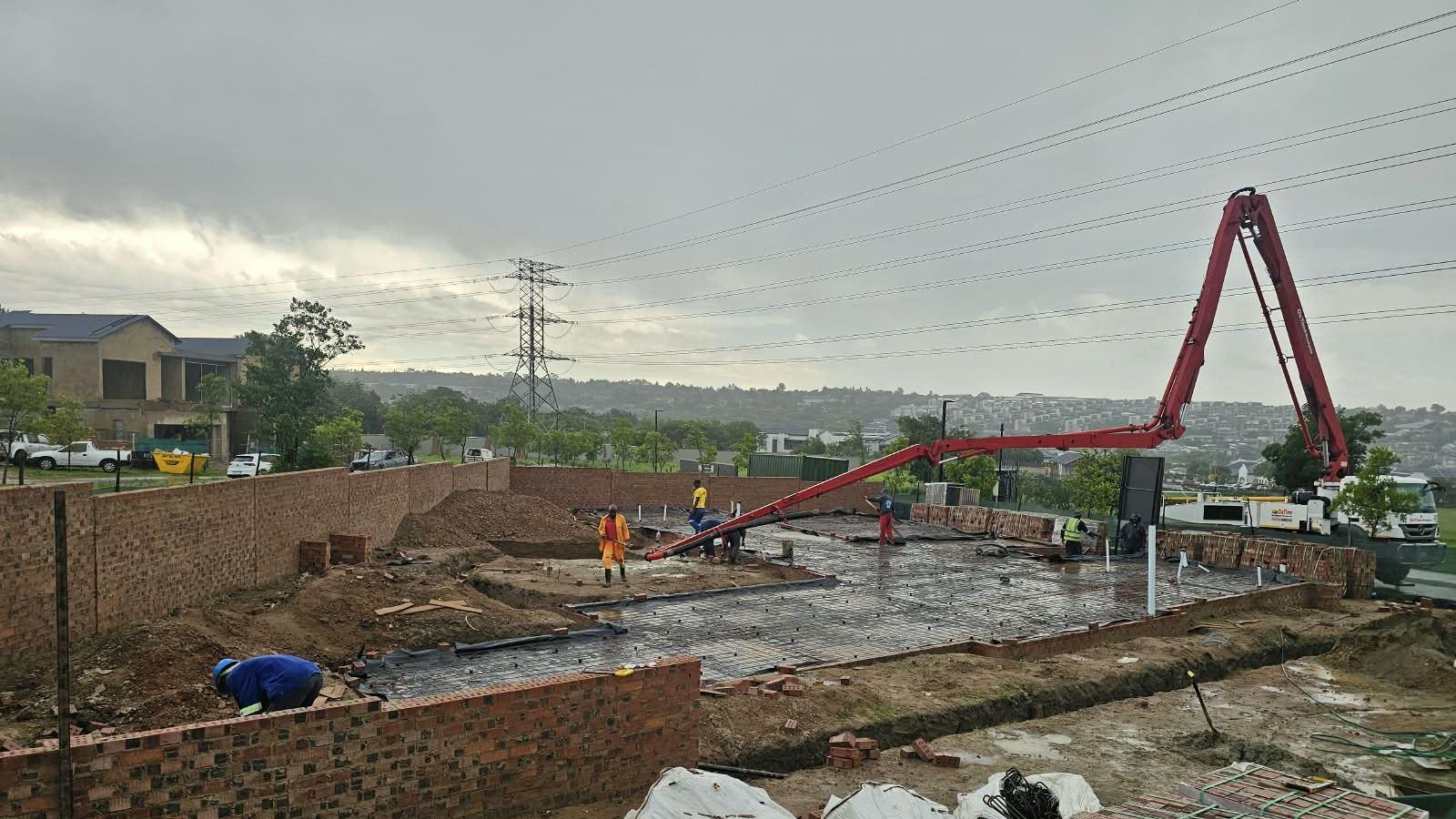 Concrete pump placing a surface bed with brick stock delivered on site